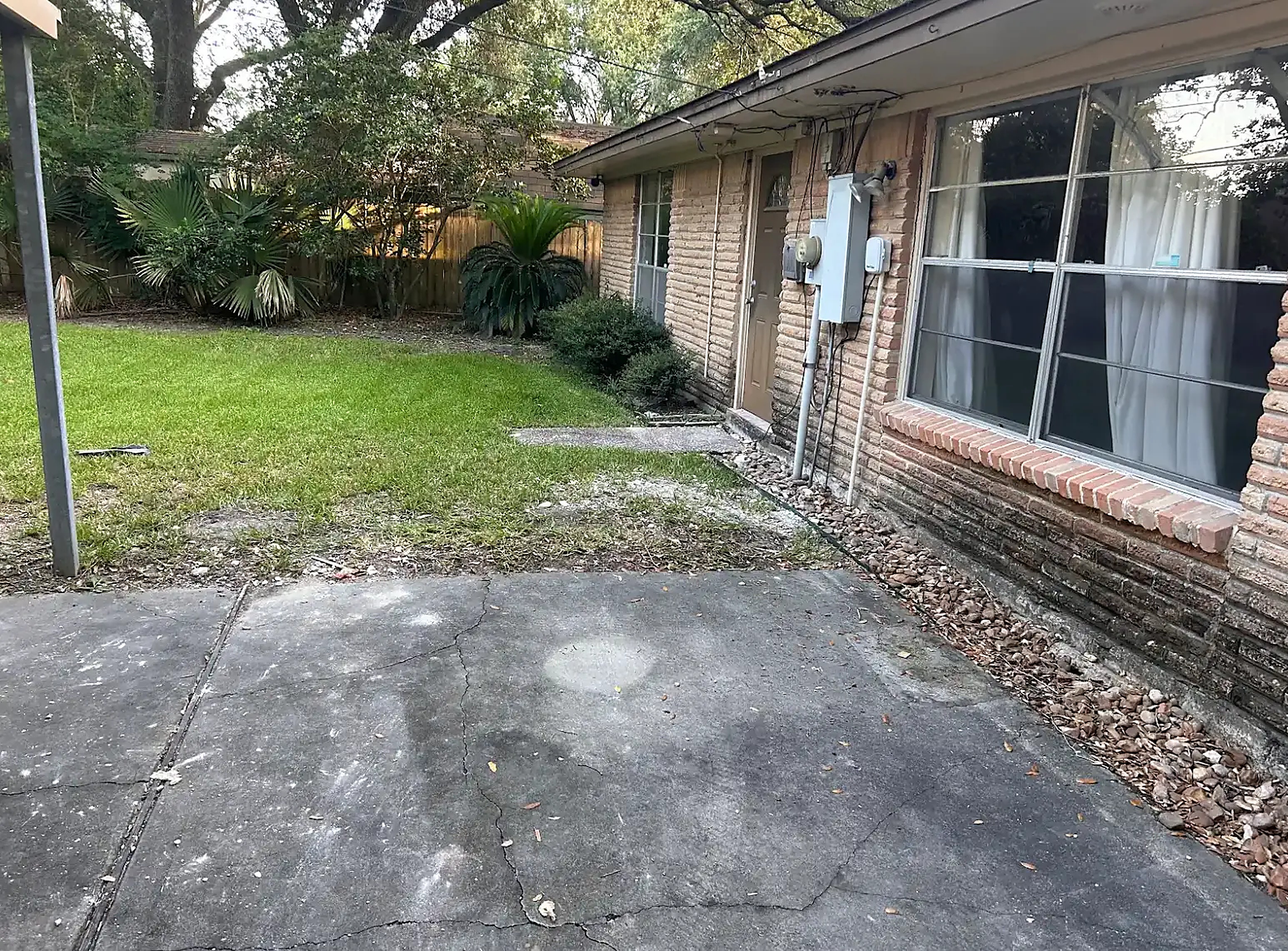 Tarped driveway loaded with broken tile, drywall chunks and demolition rubble outside a Houston home