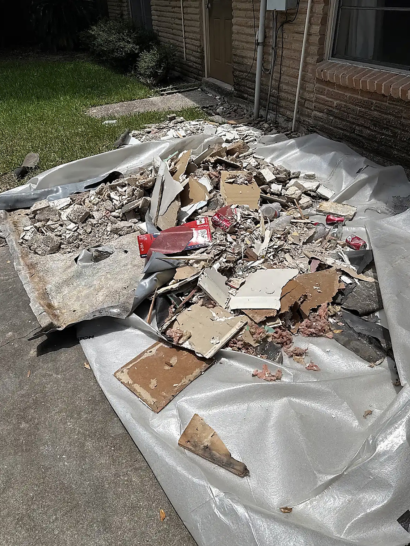 Clean patio and green lawn beside a Houston brick home after debris removal